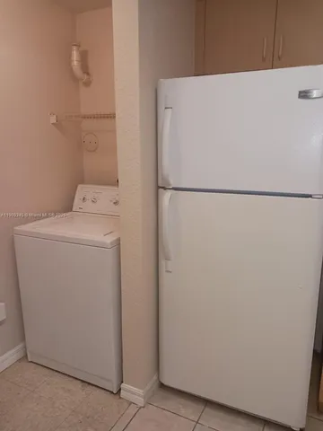 a white refrigerator freezer next to a white wall