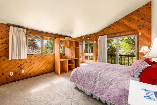 a bed sitting in a bedroom next to a window