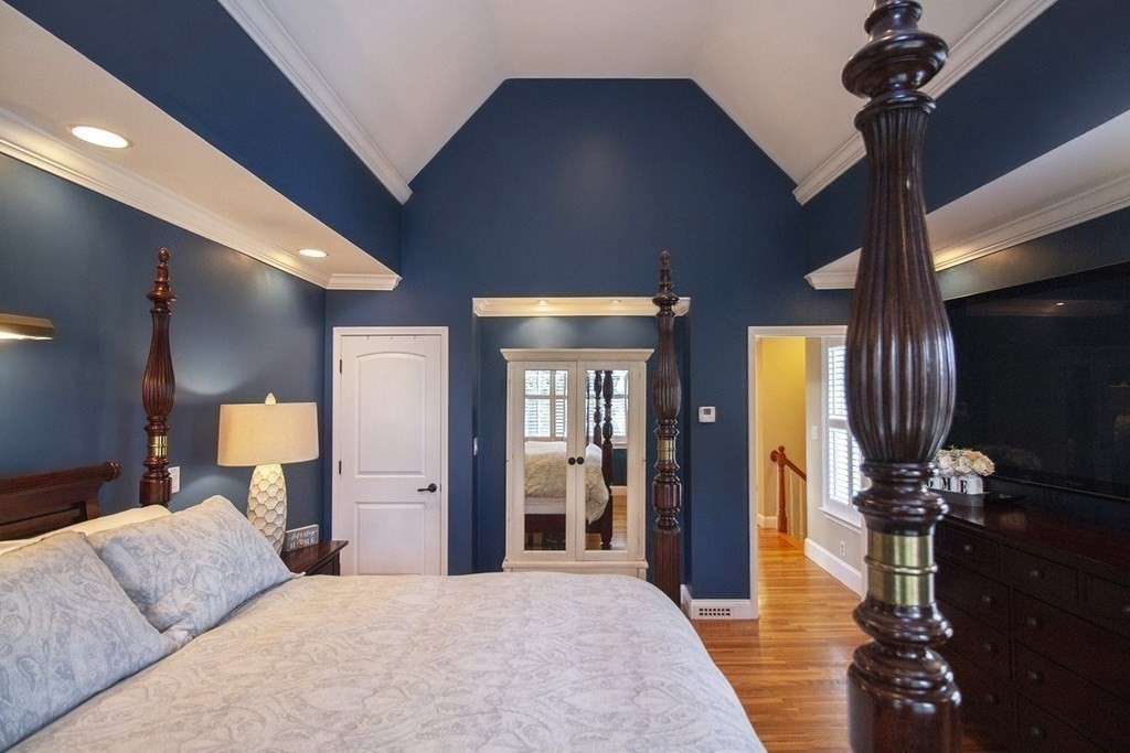 41-43 Stone Street Walpole, MA 02081 - Photo 15 of 36 a bed room with a bed mirror and a chandelier