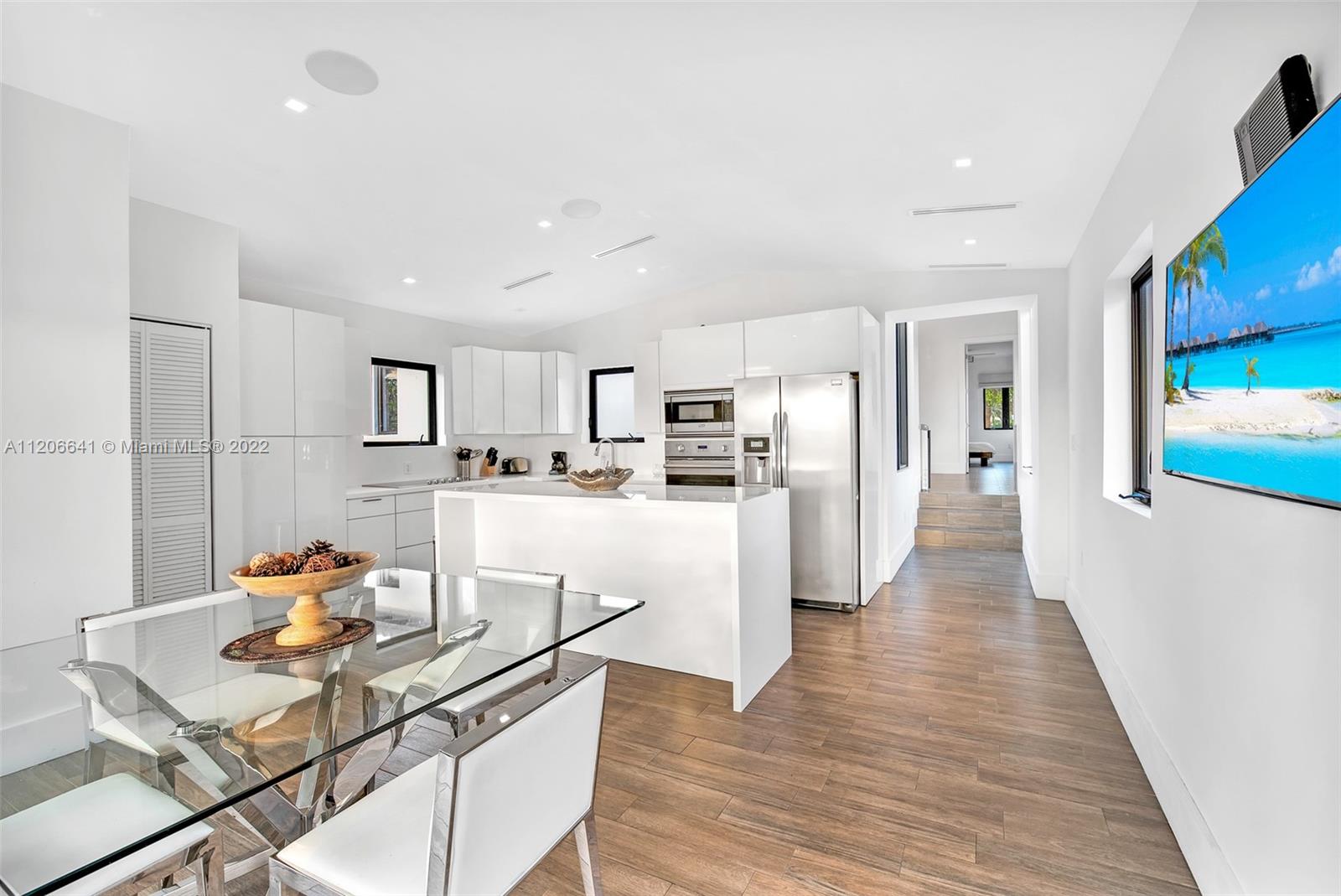 2700 North Bay Road Miami Beach, FL 33140 - Photo 26 of 42 a living room with stainless steel appliances kitchen island granite countertop furniture and a wooden floor