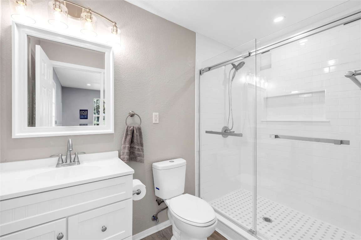 1946 Granite Cove Road Kingsland, TX 78639 - Photo 27 of 31 a bathroom with a shower sink vanity mirror and toilet