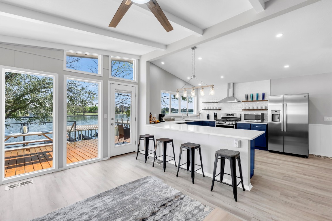 1946 Granite Cove Road Kingsland, TX 78639 - Photo 4 of 31 a kitchen with stainless steel appliances granite countertop a stove top oven a refrigerator a sink and white cabinets with wooden floor