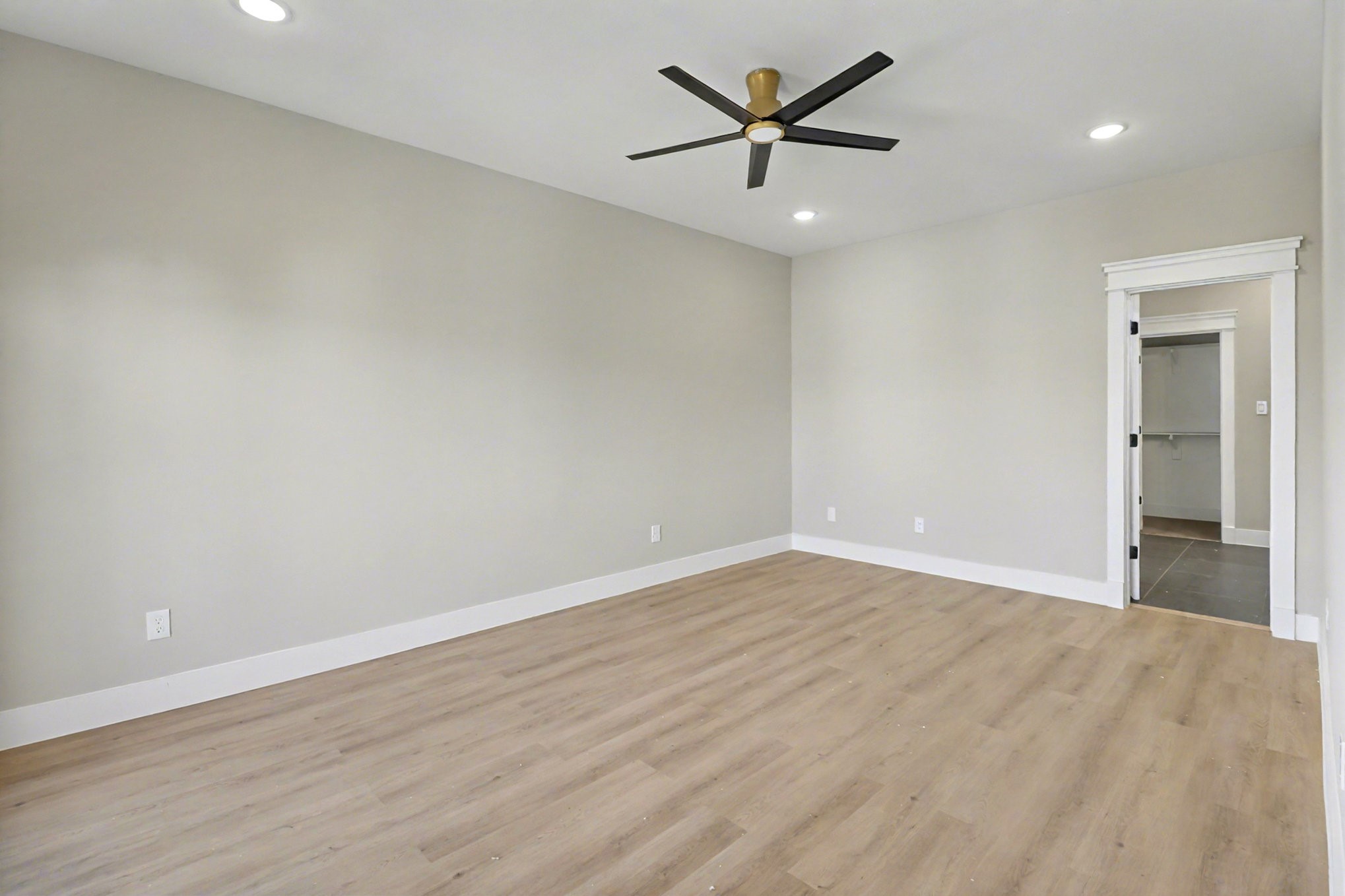 5000 Higgins Street, Unit A Houston, TX 77033 - Photo 15 of 32 an empty room with wooden floor and a ceiling fan