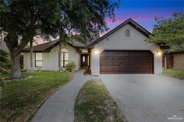 a front view of a house with a garden and trees