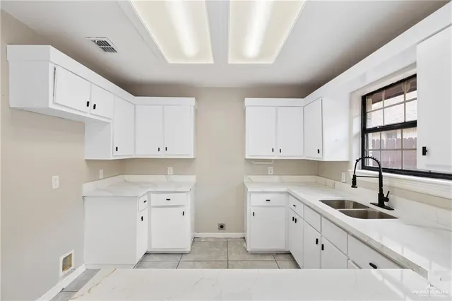 a kitchen with a sink window and cabinets