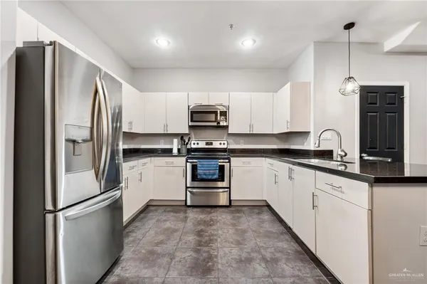 a kitchen with stainless steel appliances granite countertop a sink a stove and a refrigerator