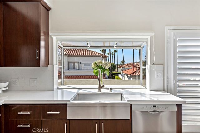 a sink with a window and a potted plant