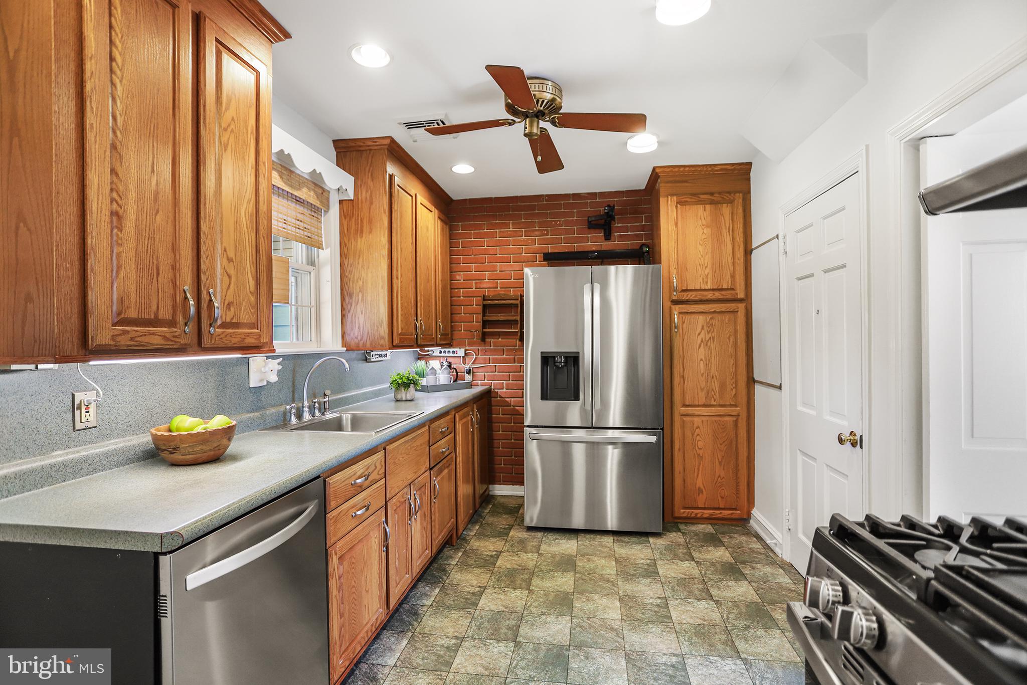 242 North Rolling Road Springfield, PA 19064 - Photo 12 of 37 a kitchen with stainless steel appliances a refrigerator a sink and wooden cabinets