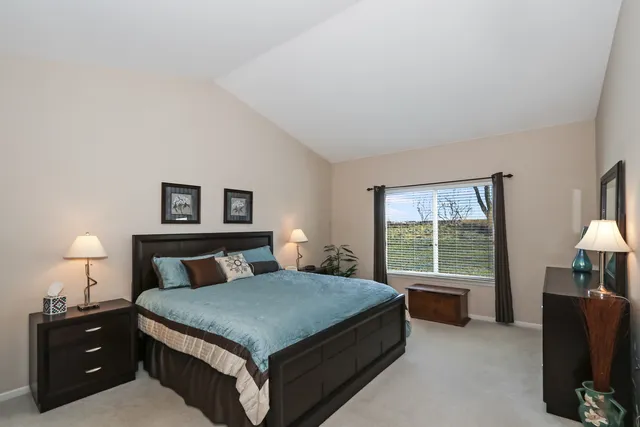 a bedroom with a bed and a lamp on table lamp