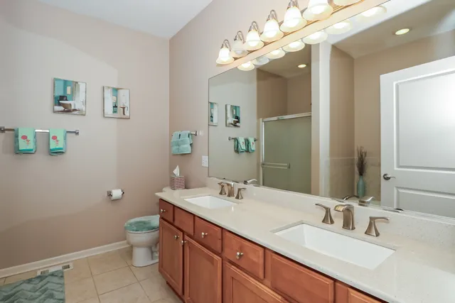 a bathroom with a granite countertop sink a toilet and a mirror