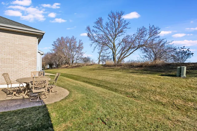 a view of a patio with table and chairs and potted plants with wooden fence