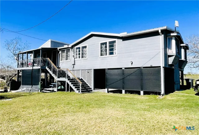 a living room with furniture a flat screen tv and floor to ceiling window