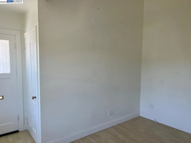 a view of a hallway with wooden floor and a bathroom