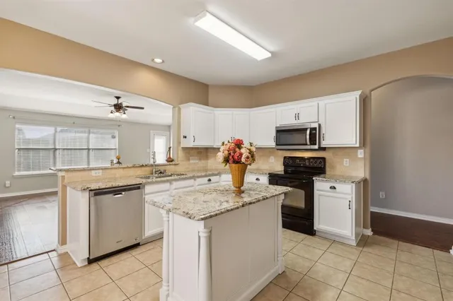 a kitchen with stainless steel appliances granite countertop a sink dishwasher stove top oven and refrigerator
