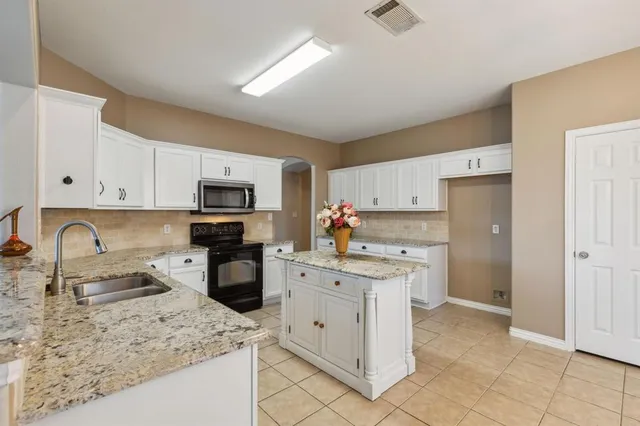 a kitchen with white cabinets sink and stainless steel appliances