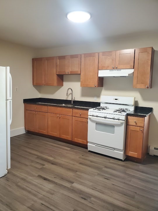 9 Victory Road, Unit 13 Boston, MA 02122 - Photo 3 of 14 a kitchen with wooden cabinets and white appliances
