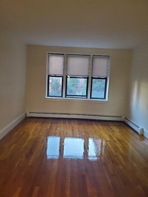 9 Victory Road, Unit 13 Boston, MA 02122 - Photo 4 of 14 an empty room with wooden floor and windows