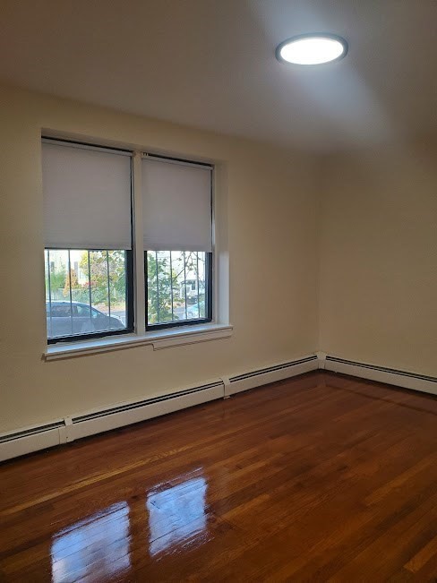 9 Victory Road, Unit 13 Boston, MA 02122 - Photo 10 of 14 a view of an empty room with wooden floor and a window