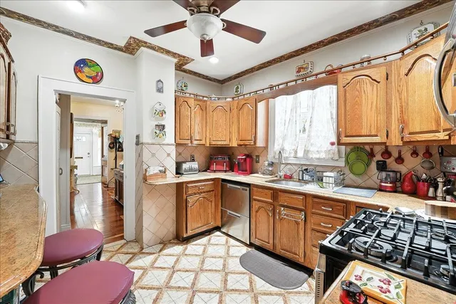 a kitchen with stainless steel appliances kitchen island granite countertop a sink stove and refrigerator
