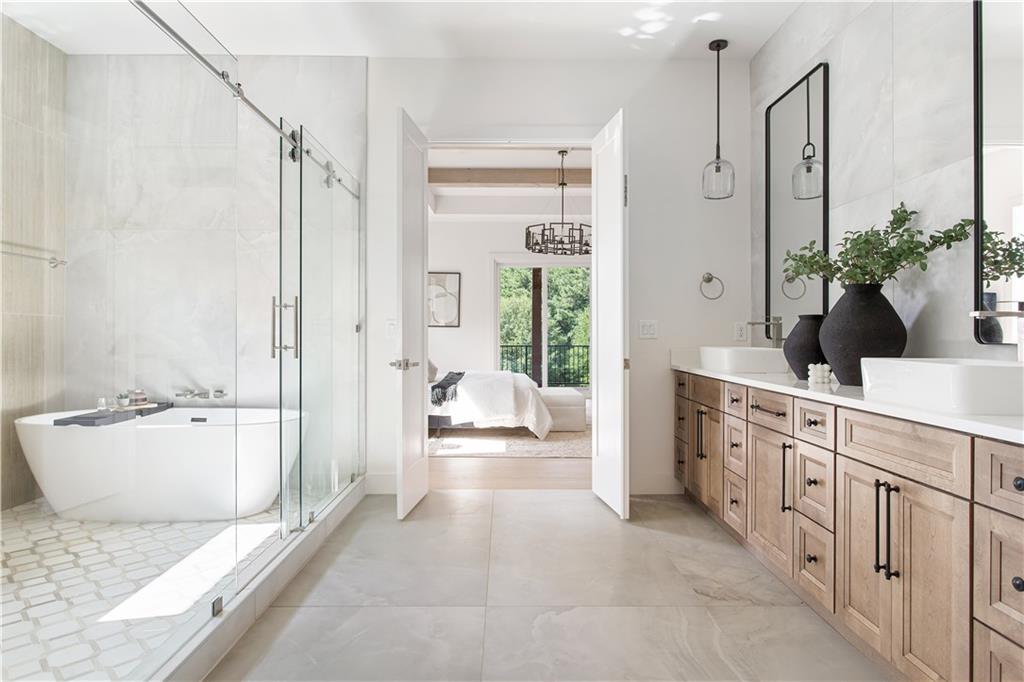 3300 Jack Glass Road Monroe, GA 30656 - Photo 36 of 54 a spacious bathroom with a double vanity sink a large mirror a bathtub and next to a window