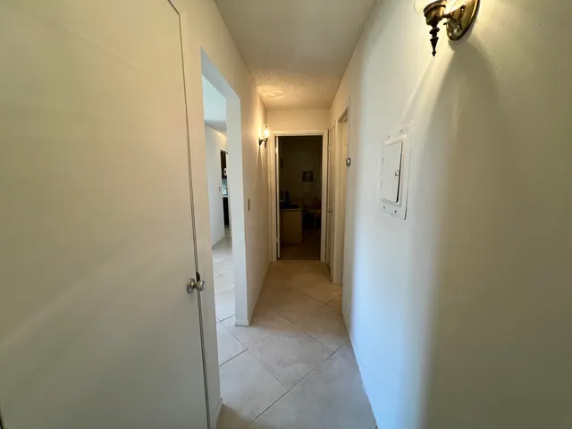 a view of a hallway with closet and a bathroom