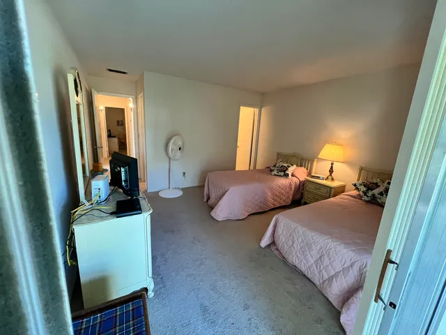 a bedroom with two beds and a dresser