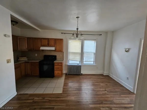 a kitchen with granite countertop a refrigerator and wooden cabinets