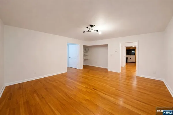 a view of an empty room with wooden floor