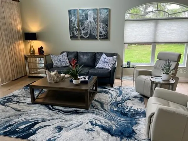 a living room with furniture a large window and a fireplace
