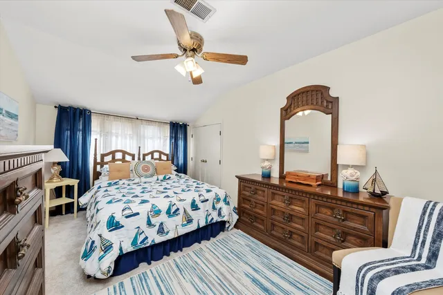 a bedroom with a bed a dresser and flowerpot