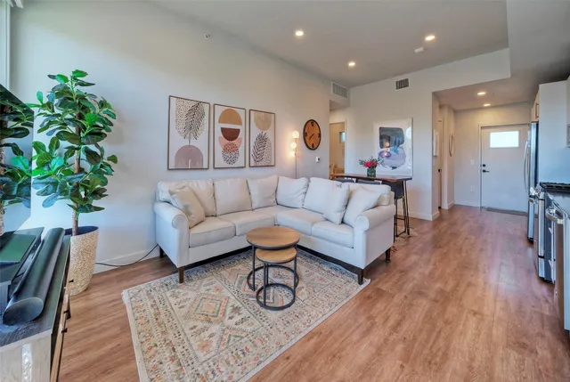 a living room with furniture and a wooden floor