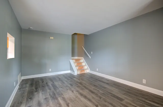 a view of an empty room with wooden floor