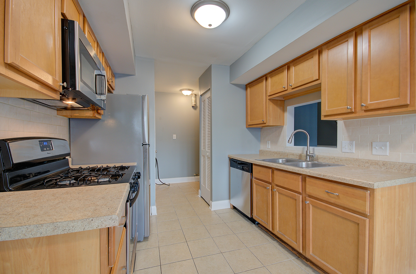 2302 Carnation Drive, Unit 317C Crest Hill, IL 60403 - Photo 7 of 17 a kitchen with a sink stove and cabinets