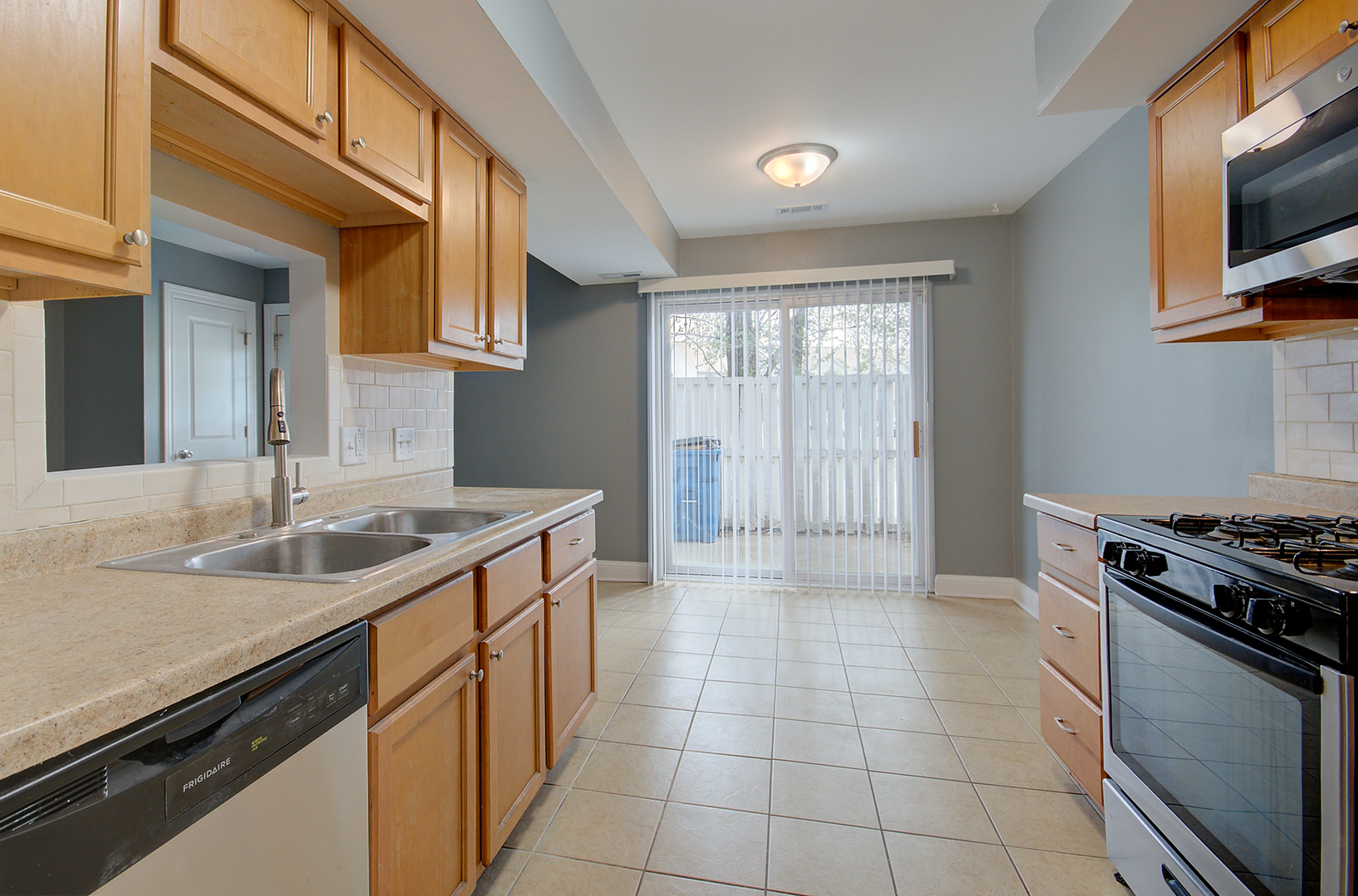 2302 Carnation Drive, Unit 317C Crest Hill, IL 60403 - Photo 8 of 17 a kitchen with a sink stove top oven and cabinets