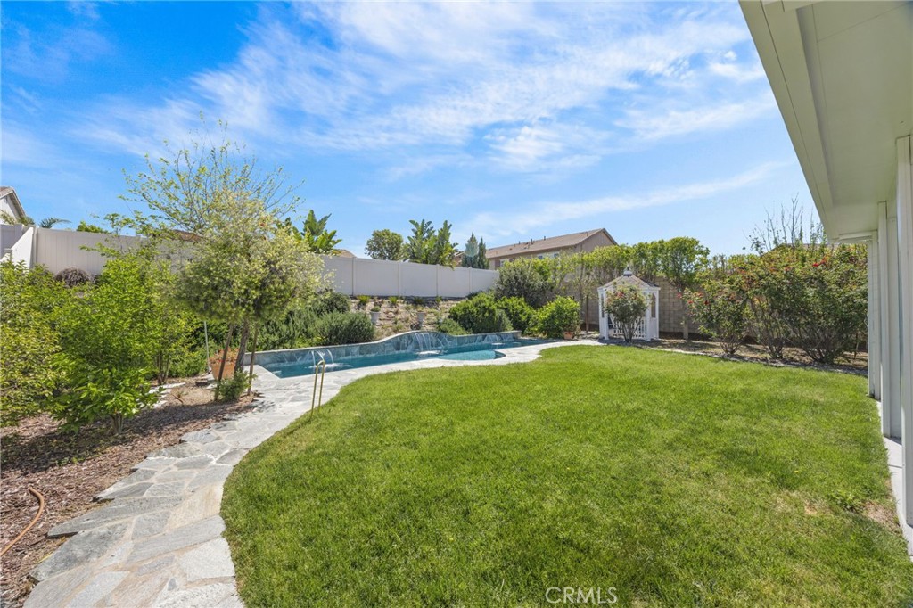23129 Rustic Oak Drive Wildomar, CA 92595 - Photo 26 of 42 Resort-style backyard and energy-efficient upgrades highlight this impressive property. Enjoy a private pool and spa surrounded by lush landscaping, mature greenery, and multiple outdoor seating areas—perfect for entertaining or relaxing. The home is equipped with a fully installed solar system for enhanced efficiency and long-term savings. Situated on a well-sized lot with added privacy and functional outdoor space, this property offers the ideal blend of comfort, sustainability, and California outdoor ...