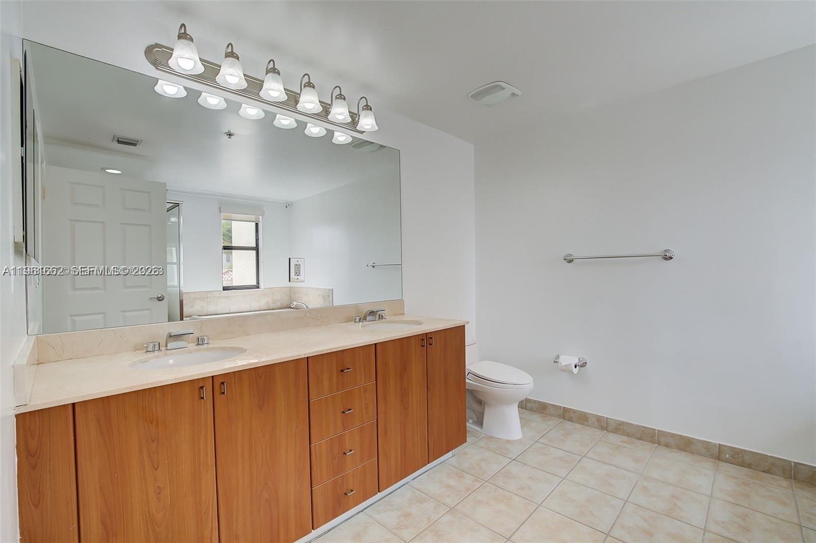 888 Douglas Road, Unit 1401 Coral Gables, FL 33134 - Photo 11 of 43 a bathroom with a double vanity sink mirror and toilet