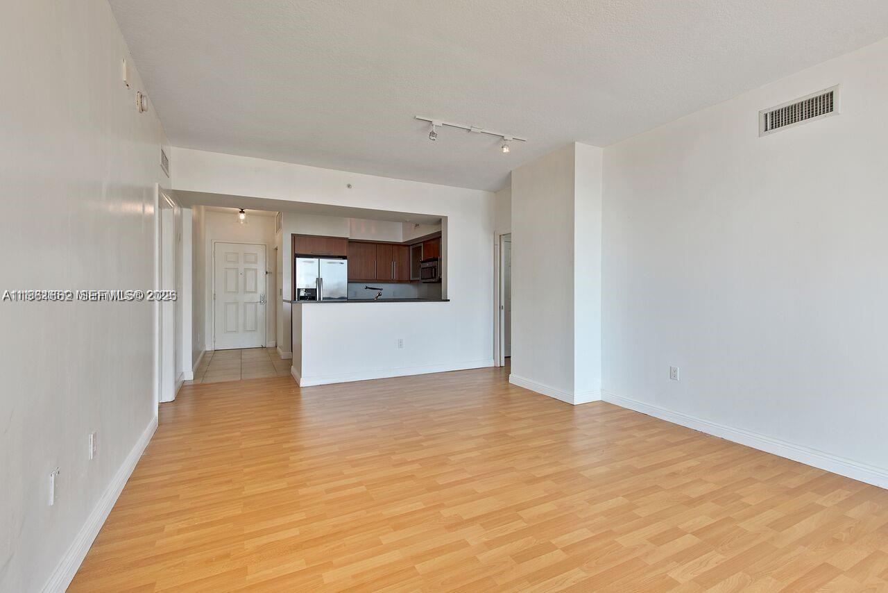 888 Douglas Road, Unit 1401 Coral Gables, FL 33134 - Photo 13 of 43 a view of a big room with wooden floor and a kitchen