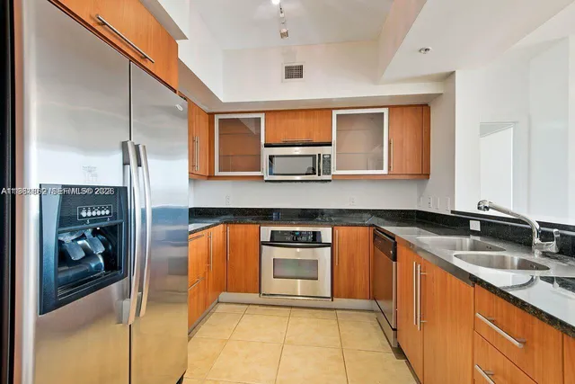 a kitchen with stainless steel appliances granite countertop a sink and cabinets