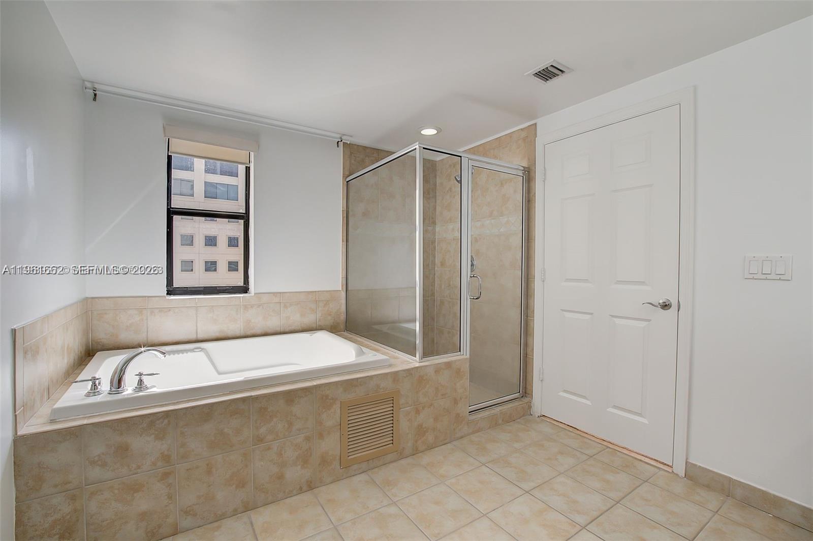 888 Douglas Road, Unit 1401 Coral Gables, FL 33134 - Photo 5 of 43 a bathroom with a bathtub and shower