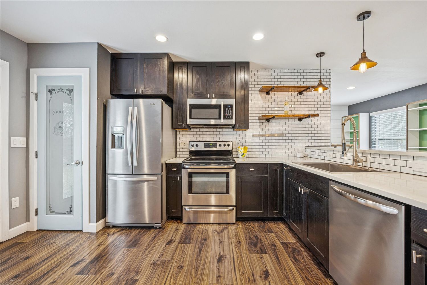 2921 Pecan Springs Road Austin, TX 78723 - Photo 11 of 21 a kitchen with kitchen island granite countertop stainless steel appliances and wooden floor