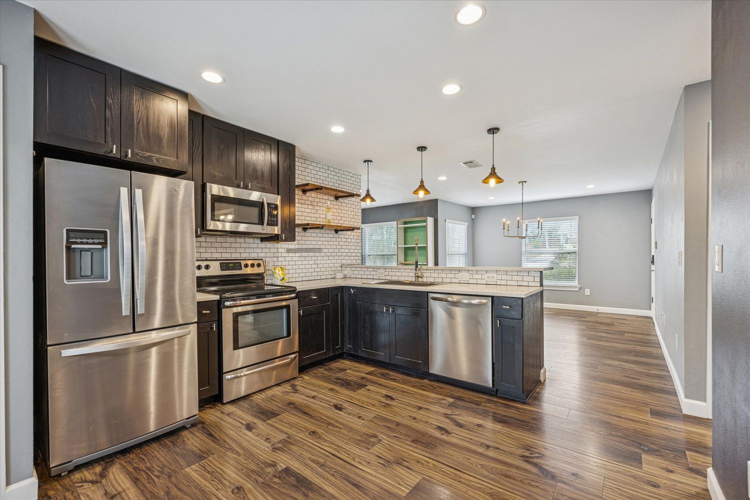 2921 Pecan Springs Road Austin, TX 78723 - Photo 12 of 21 a kitchen with stainless steel appliances granite countertop a refrigerator a sink dishwasher a stove and white countertops with wooden floor