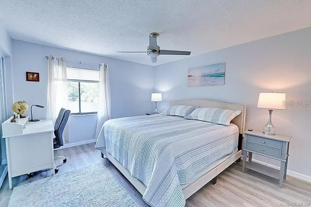 a bedroom with a bed desk chair and window
