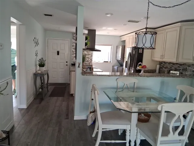 a kitchen with kitchen island a stove a table and chairs in it