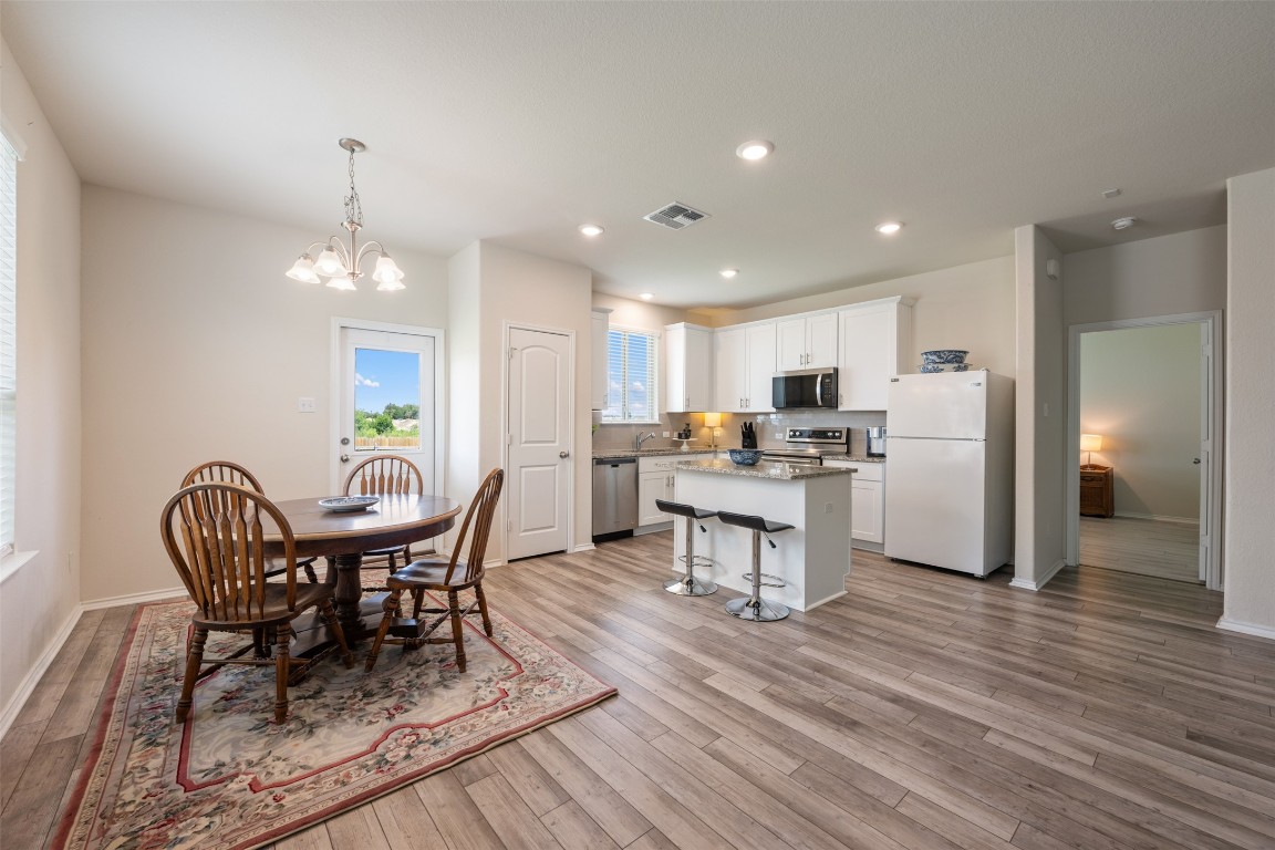 225 Gunther Way Taylor, TX 76574 - Photo 14 of 40 a view of a dining room with furniture and wooden floor