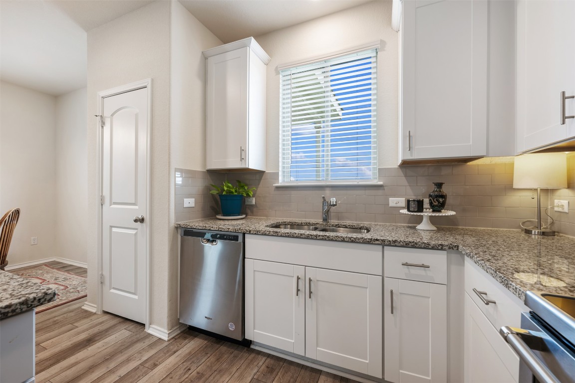 225 Gunther Way Taylor, TX 76574 - Photo 18 of 40 a kitchen with appliances cabinets and a wooden floor