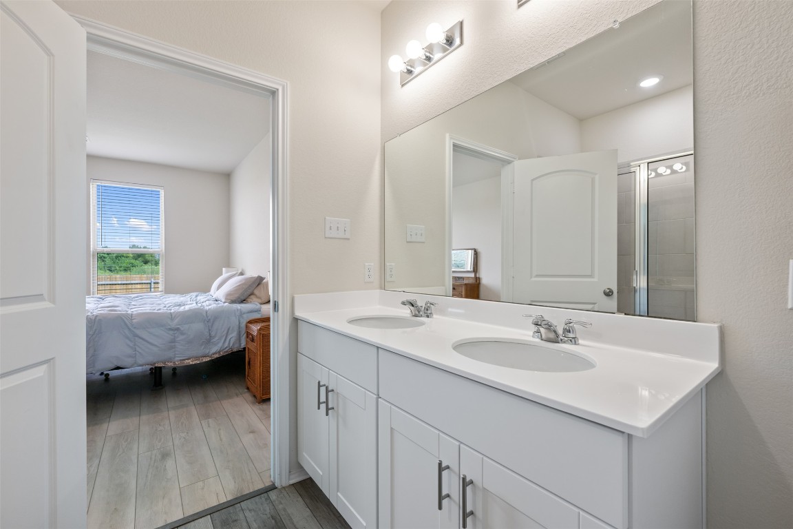 225 Gunther Way Taylor, TX 76574 - Photo 24 of 40 a en suite bathroom with a double vanity sink and a mirror