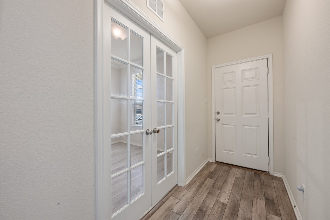 225 Gunther Way Taylor, TX 76574 - Photo 5 of 40 a view of a hallway with wooden floor and closet
