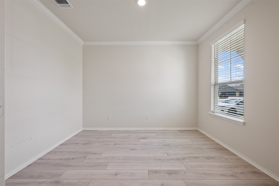 225 Gunther Way Taylor, TX 76574 - Photo 6 of 40 a view of an empty room with wooden floor and a window