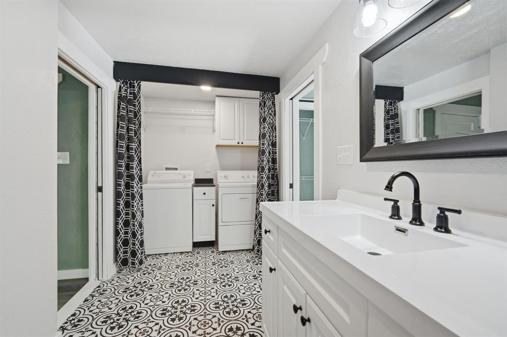 3325 Dove Creek Road Cleburne, TX 76031 - Photo 14 of 40 Bathroom vanity featuring a white rectangular sink, matte black faucet, and white paneled cabinetry