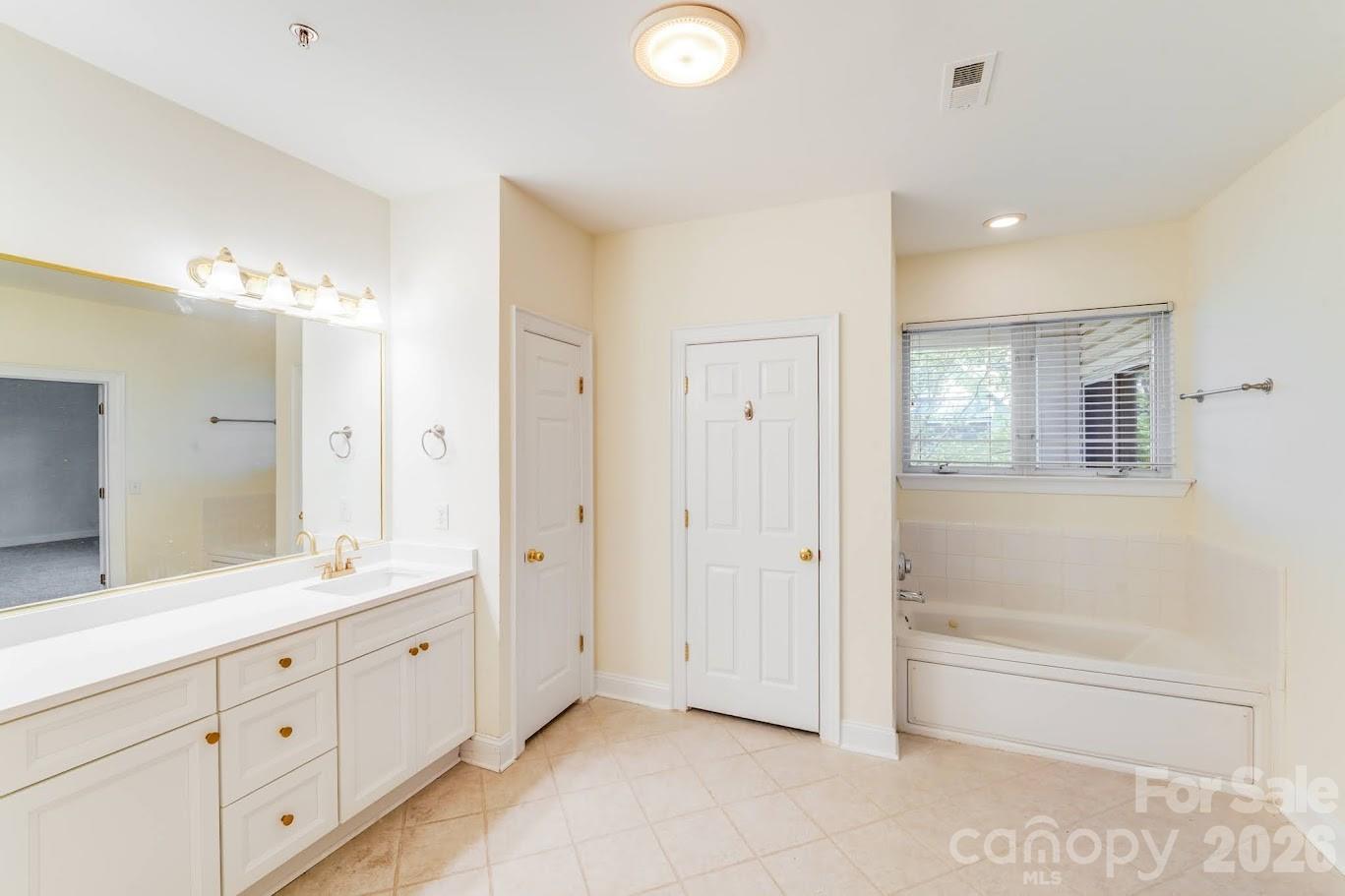 5601 Fairview Road, Unit 10 Charlotte, NC 28209 - Photo 19 of 28 a spacious bathroom with a mirror a double vanity sink and a mirror